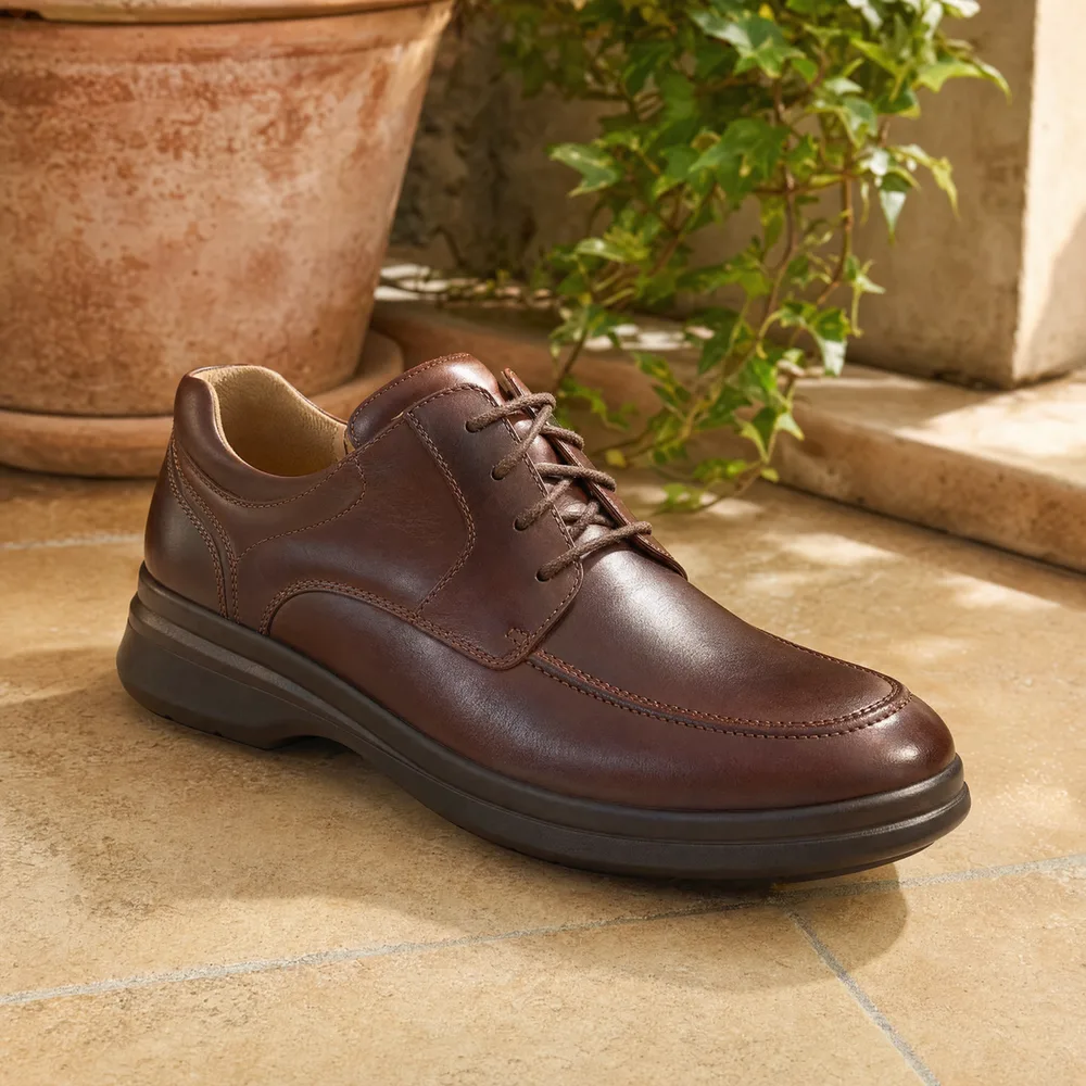 Chaussure orthopédique confortable Marcel, derby homme en cuir posé sur un fond neutre chaleureux